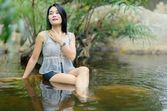 Young Woman Enjoying Peaceful Moment in Wang Takrai Waterfall Pool