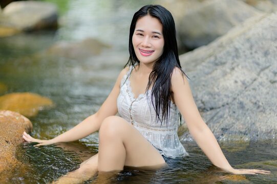 Woman Relaxing by Tranquil Wang Takrai Waterfall in Nakhon Nayok