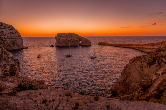 Sunset Landscape over Dwejra Bay Featuring Fungus Rock (Il-Gebla tal-General), Anchored Sailboats and Calm Sea
