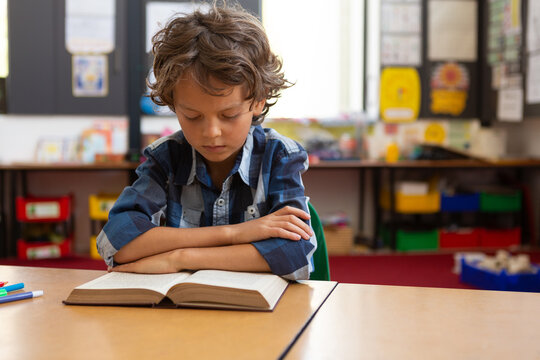 Schoolboy reading a book in the classroom