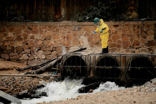 Hazardous chemical contamination inspection concept. Environmental scientists in protective suits collecting polluted water samples near industrial wastewater area. pollution, hazmat, safety,