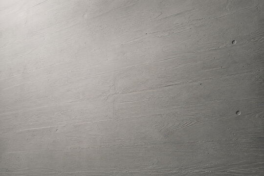 A grey, textured wall with subtle striations dominates the frame, presenting a smooth, matte surface.