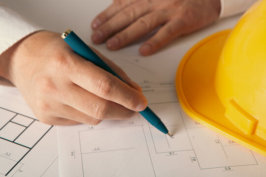 Architect working on blueprints at office, closeup. Construction concept