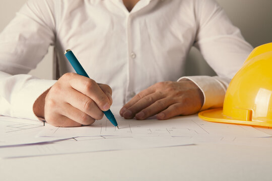 Architect working on blueprints at office, closeup. Construction concept