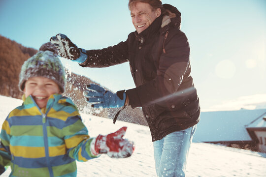 Italy, Val Venosta, Slingia, father and son having a snowball fight