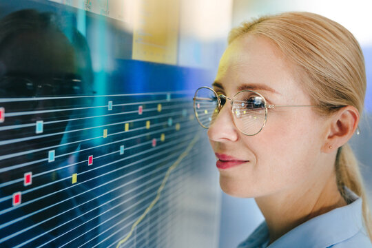 Businesswoman analyzes digital data chart on a modern screen indoors