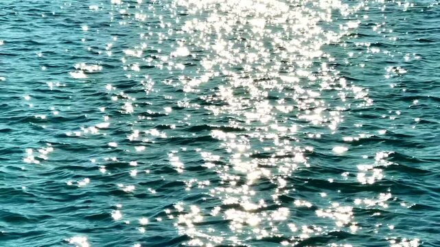 Sparkling Sunlight Reflections Glimmering On Rippled Blue Water 