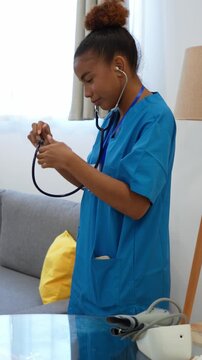 Young latina home health nurse using stethoscope while examining senior patient during medical consultation in living room