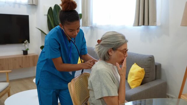 Latina home health nurse using a stethoscope to examine an elderly woman's lungs during a medical checkup visit at home