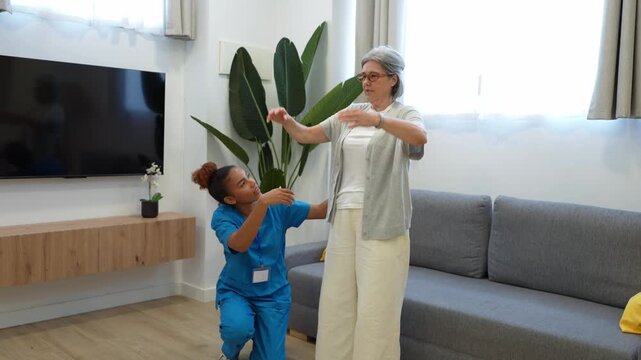 Attentive latina nurse assisting an elderly woman performing stretching exercises during a home healthcare visit
