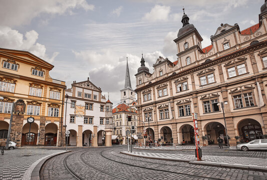 Prague, Czech Republic. Retro tram track curves through a historic square with vintage European architecture. Old fashioned buildings and classic cobblestone streets capture a timeless nostalgic vibe.