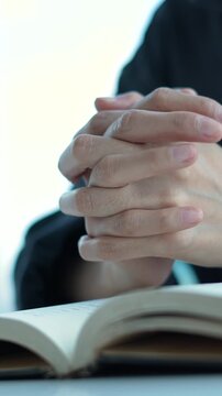 holding hands with praying book. A Christian's devout prayer time, placing both hand on the Bible and offering earnest in silence. religion concept.