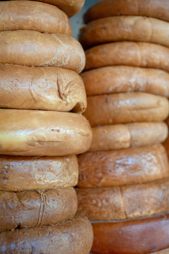 Smoked Sulguni cheese wheel background. Traditional Georgian dairy product stack