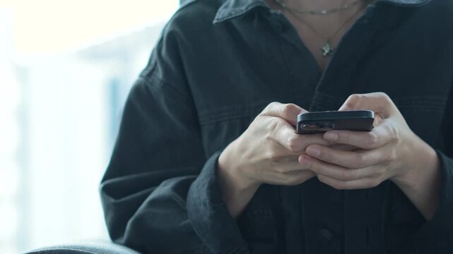 woman holds smart phone in her hands and scrolls through the news feed. Close up of hand uses mobile. point finger on screen, texting text message.