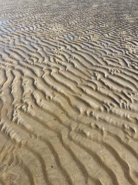 Ocean Water Forming Gentle Waves on a Sandy Beach