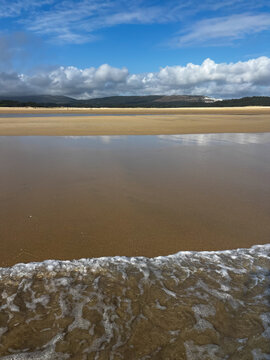 Ocean Water Forming Gentle Waves on a Sandy Beach