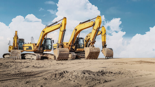 Several excavators are parked on a dirt construction site, with their arms and buckets lowered during the day