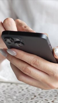 woman holds smart phone in her hands and scrolls through the news feed. Close up of hand uses mobile. point finger on screen, texting text message.