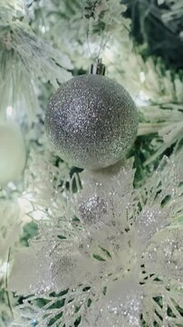 Glistening Winter Wonderland: A Close-Up Journey Through a Snow-Kissed Christmas Tree Adorned with Twinkling Lights and Delicate Decor