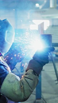 An Expert Welder Performing Precision Work Amid Bright Sparks and Blue Light in an Industrial Setting, Showcasing Skill and Craftsmanship in Metal Fabrication
