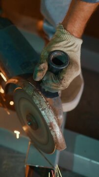 A craftsman using a powerful grinder to cut metal, creating sparks and showcasing skilled craftsmanship in a workshop environment, demonstrating precision and focus.