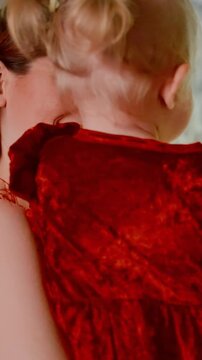 Warm and Joyful Celebration with Child in Red Dress, Capturing a Heartwarming Moment of Togetherness Amidst a Festive Environment Full of Lights