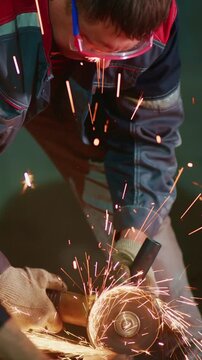 Craftsman Working with Metal and Grinder, Creating Sparks During a Precision Engineering Task in an Industrial Workshop Setting
