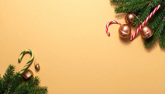 Candy canes, golden bells and pine branches on peach background
