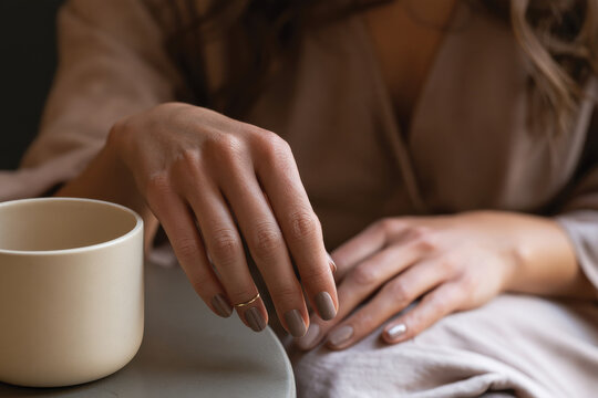 An artistic shot focusing on hands elegantly holding a cup, symbolizing simplicity and elegance, capturing the beauty of human touch and a moment of tranquility.