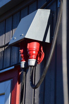 Industrial three phase electrical outlet with heavy duty cable on wall