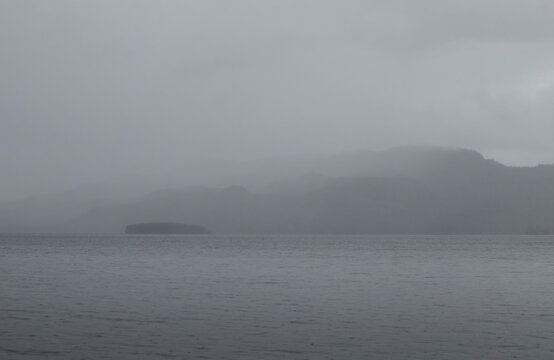 Fog covering mountains behind a lake near Soldotna, Alaska on a summer day.