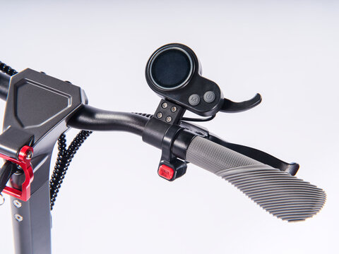 Close-up of electric scooter handlebar with LCD display, throttle and control buttons, isolated white background