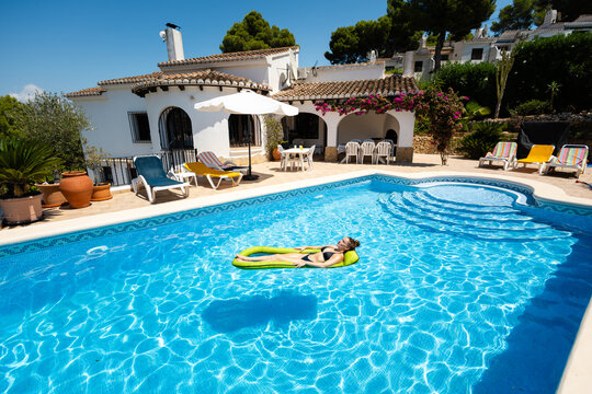 Sunny poolside scene with woman on green float