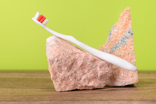 Toothbrush with granite stones  on a green background