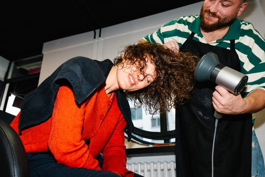 Hairdresser drying curls with diffuser