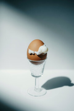 Brown Egg in a Glass With White Substance on Top