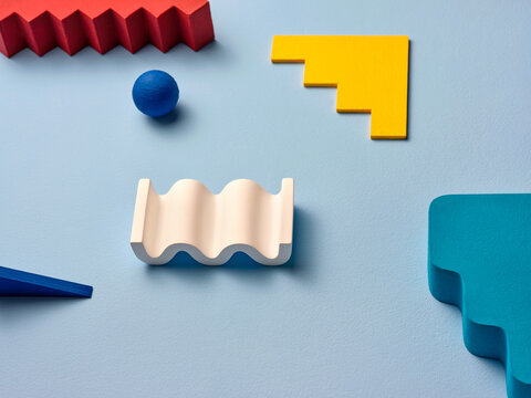 Colorful geometric wooden shapes artfully arranged on blue