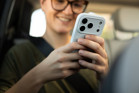 woman  using smartphone in car during sunny day