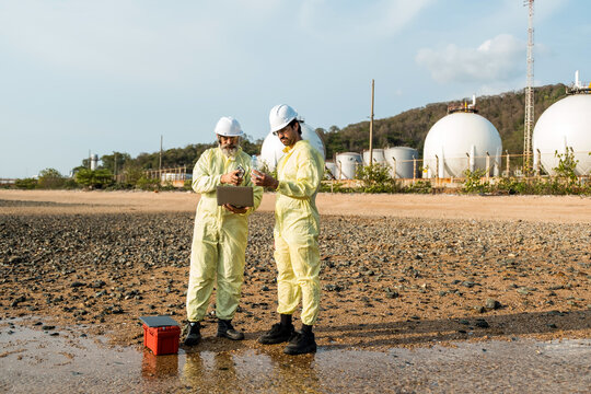 Two industrial workers inspect equipment at a storage facility