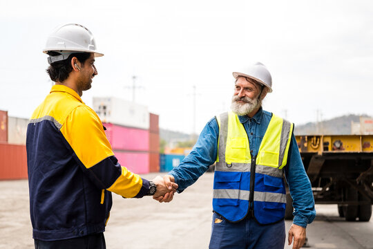 Construction workers shake hands at a shipping yard