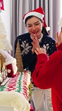 Women in Santa hats celebrate beside a decorated Christmas table