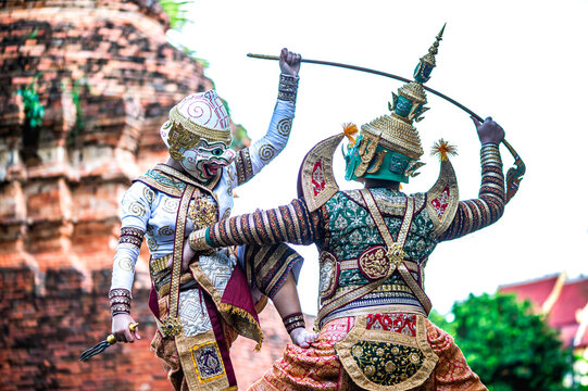 Two Thai Khon performers in full costume as the white monkey warrior Hanuman and the demon king Thosakan performing traditional and legendary rivalry from the Ramayana Thai famous literature outdoor