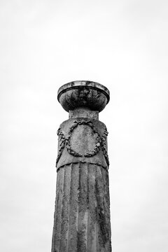 Ancient stone column with carved laurel wreath