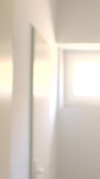 Empty school corridor with closed doors and bright window at end, high