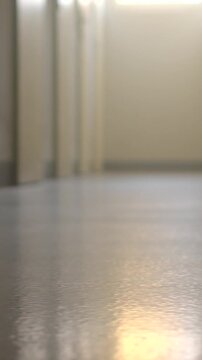 Low-angle corridor floor with reflective linoleum and distant closeds