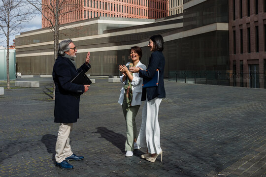 multiracial and diverse business adult group of people together in a winter morning outdoors at cityscape. Successful Entrepreneurs multigenerational teamwork in city urban scene 