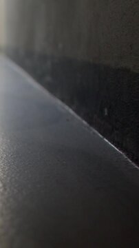 Low-angle closeup of floor edge and painted wall with narrow gap and s