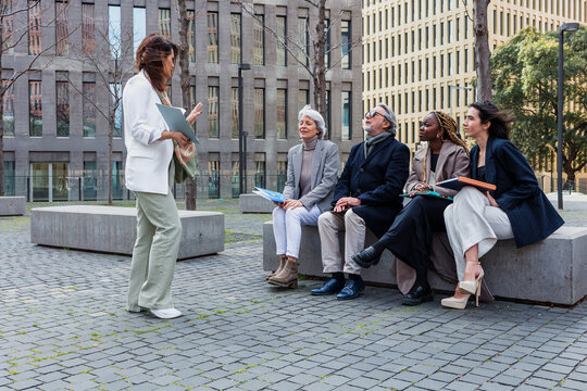 multiracial and diverse business adult group of people together in a winter morning outdoors at cityscape. Successful Entrepreneurs multigenerational teamwork in city urban scene 