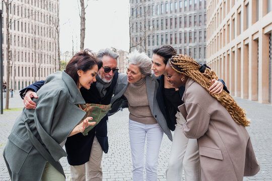 multiracial and diverse business adult group of people together in a winter morning outdoors at cityscape. Successful Entrepreneurs multigenerational teamwork in city urban scene 