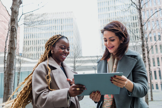 diverse business adult women together in a winter morning outdoors at cityscape. Successful Entrepreneurs multigenerational and multiracial female teamwork in city urban scene 